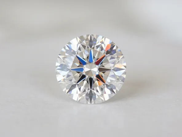 Single brilliant cut diamond on light background showing sparkle and brilliance, gemology photography